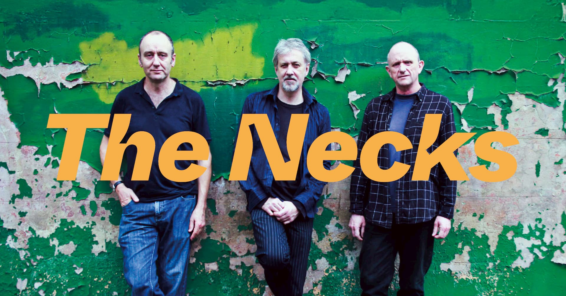Three men stand against a green, peeling wall with the words "The Necks" in large orange text across the image.
